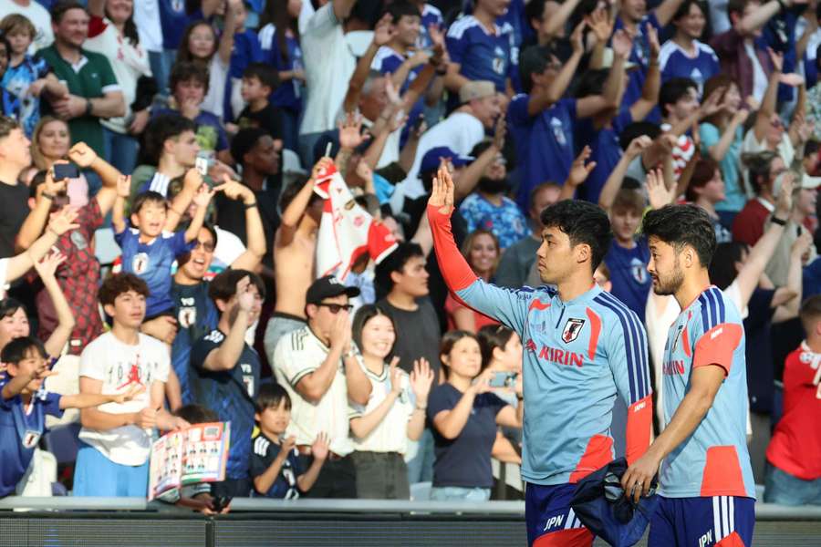 Wataru Endo and Yukinari Sugawara wave to supporters at a Japan training session in Nashville.