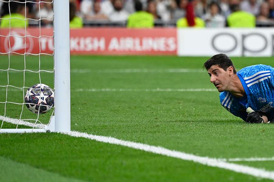 El portero belga del Real Madrid Thibaut Courtois cae cuando el centrocampista belga del Manchester City Kevin De Bruyne marca el primer gol de su equipo.