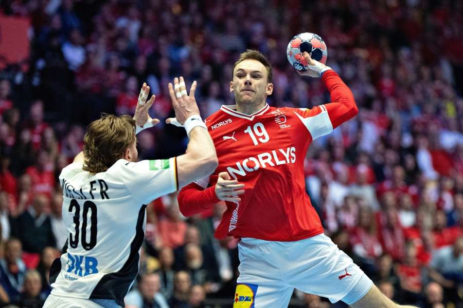 Mathias Gidsel oddaje rzut na bramkę, mimo oporu Toma Kieslera