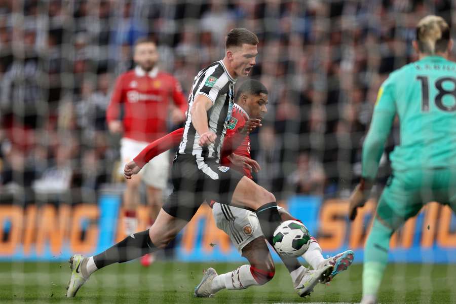 This shot from Manchester United's English striker Marcus Rashford (C) is deflected by Newcastle United's Dutch defender Sven Botman (L)