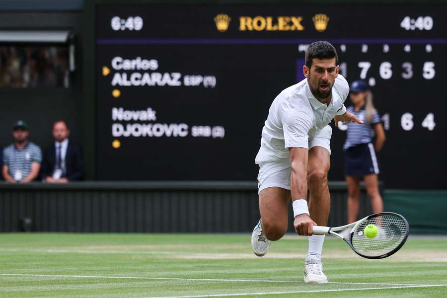 Novak Djokovic din Serbia îi returnează mingea lui Carlos Alcaraz din Spania