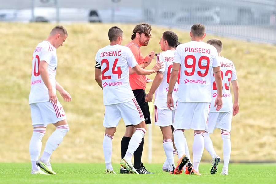 Rakow Czestochowa's players argue with referee Lino Heiduck after the red card