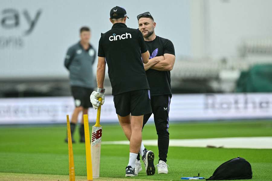 Coach Brendon McCullum (R) speaks to England's Joe Root prior to the start of the match