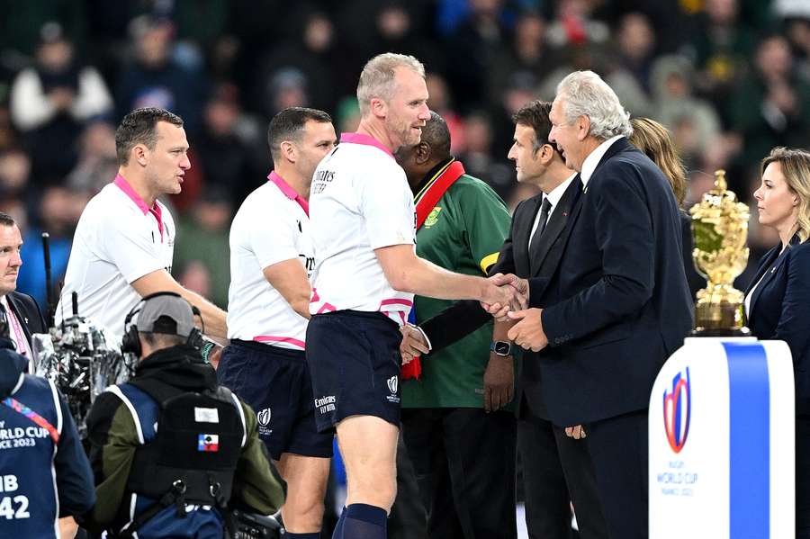 Referee Wayne Barnes shakes hands with Sir Bill Beaumont, Chairperson of World Rugby, as he collects his medal after the Rugby World Cup final
