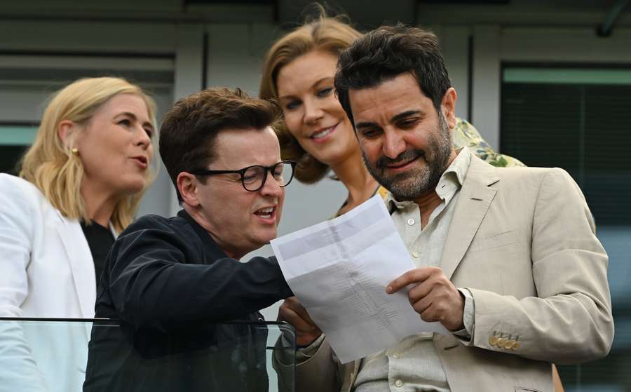 British TV host Declan Donnelly (2nd L) looks at the team sheet with Newcastle United Director, Mehrdad Ghodoussi (R) and Newcastle United's English minority owner Amanda Staveley