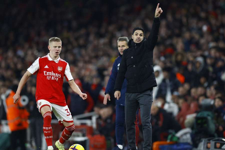 Arsenal's Oleksandr Zinchenko in action as Arsenal manager Mikel Arteta looks on