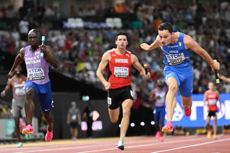 Italy's Filippo Tortu crosses the finish line ahead of Britain's Eugene Amo-Dadzie during the men's 4x100m relay heats