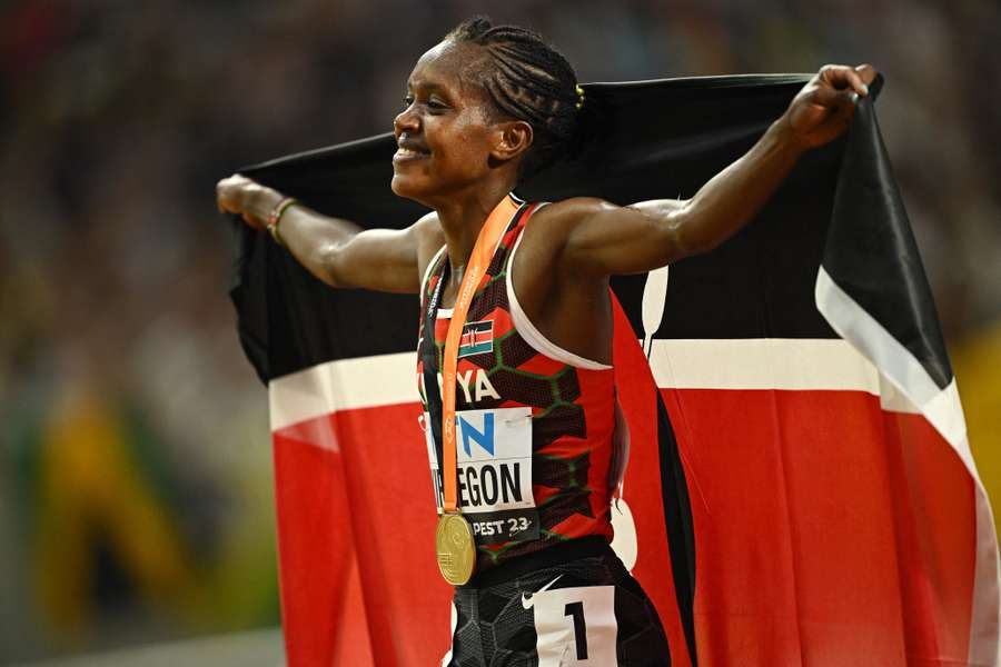 Faith Kipyegon hoists the Kenyan flag high after winning the 5,000m title