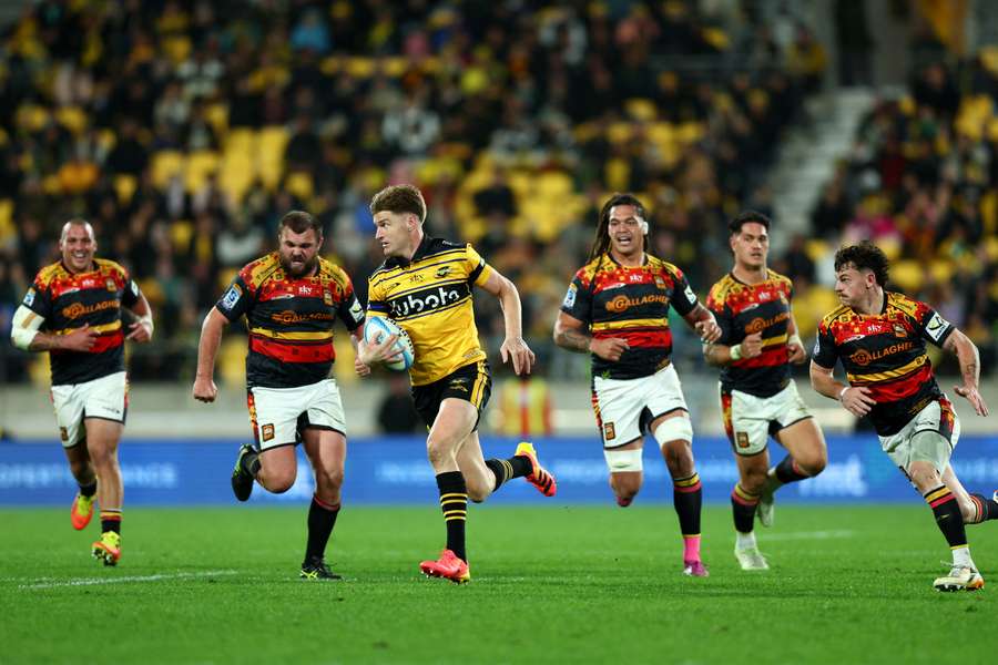 Jordie Barrett charging forward with ball in hand during the 2026 Super Rugby grand final. Jordie Barrett charging forward with ball in hand during the 2026 Super Rugby grand final.