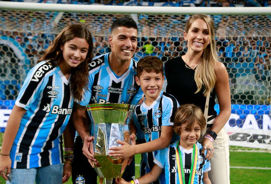 Luis Suárez, con su familia y uno de los trofeos conquistados