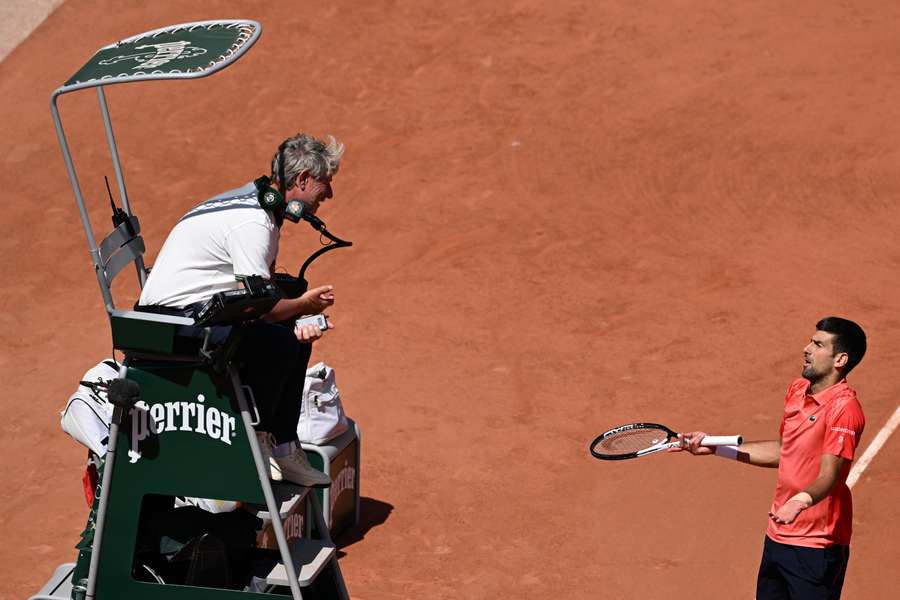 Serbia's Novak Djokovic (R) argues with umpire as he plays against US Aleksandar Kovacevic