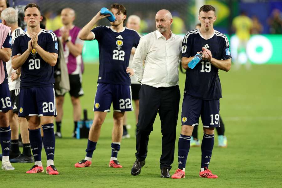 Scotland manager Steve Clarke consoles his players after their disappointing loss to Brazil.