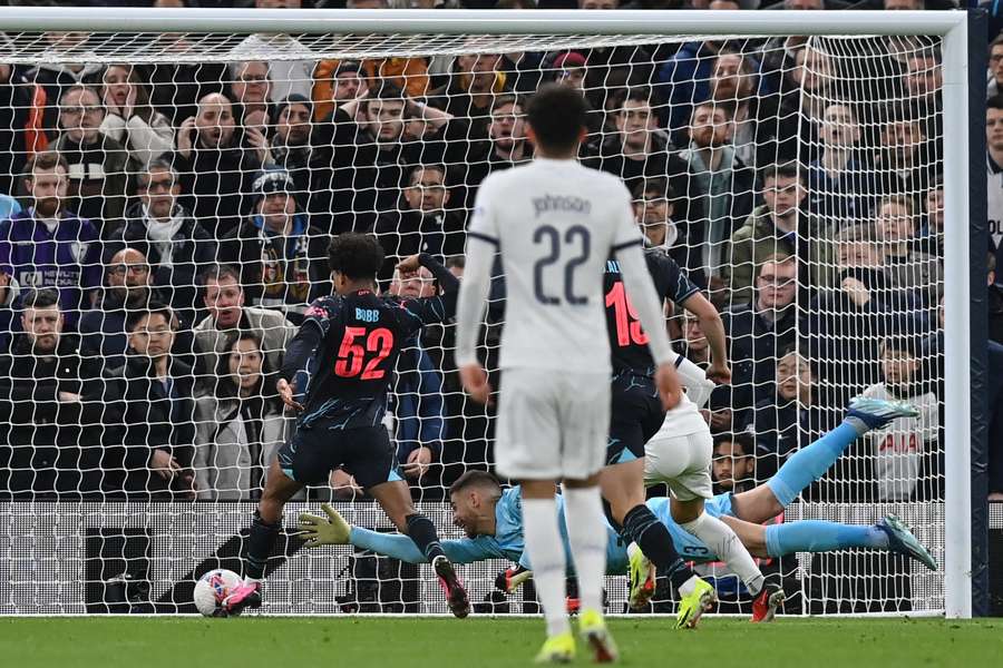 Manchester City's Norwegian midfielder #52 Oscar Bobb (L) scores past Tottenham Hotspur's Italian goalkeeper #13 Guglielmo Vicario (R) but the goal is disallowed for offside