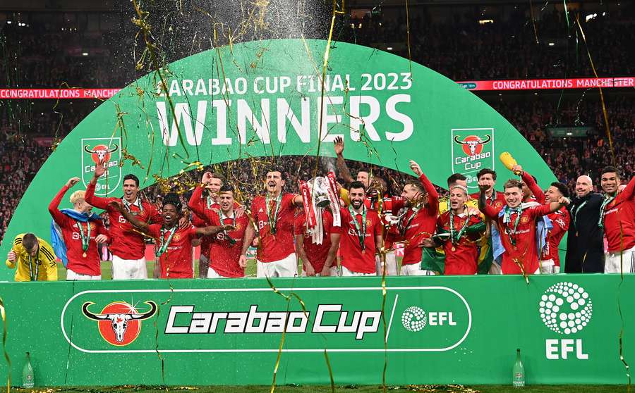 Manchester United's players celebrate with the trophy after their victory in the English League Cup final f