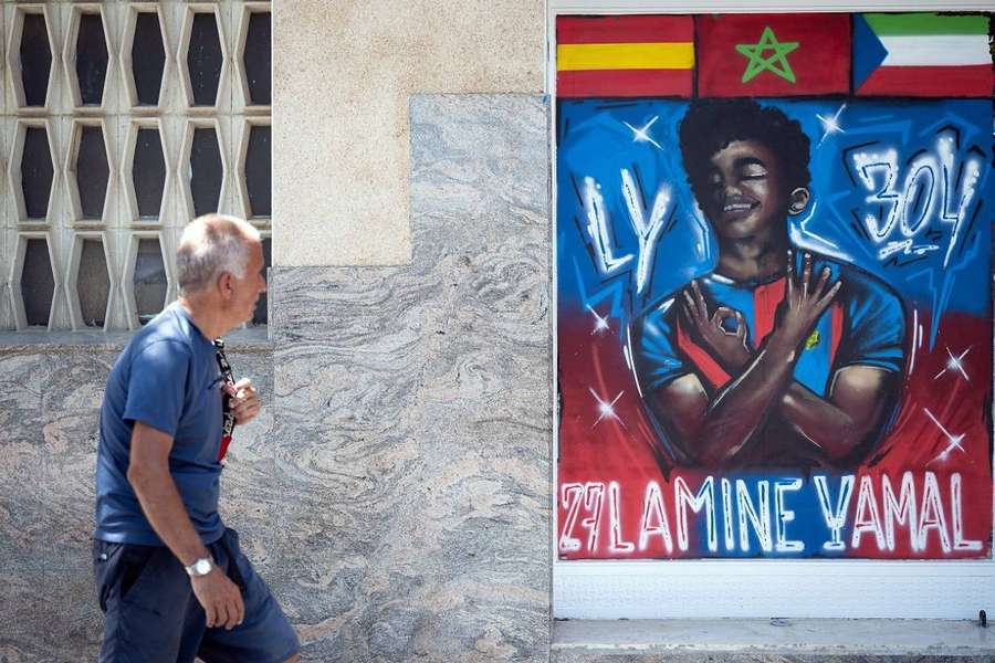 Un hombre observa el mural de Lamine.