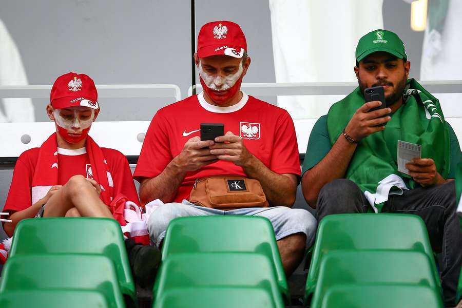 Fans van Polen en Saoedi-Arabië hebben een uur voor de wedstrijd vooral aandacht voor hun telefoon