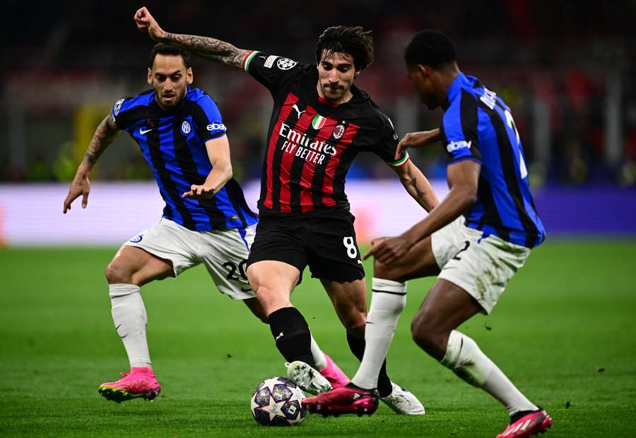 Inter Milan's Turkish midfielder Hakan Calhanoglu, AC Milan's Italian midfielder Sandro Tonali and Inter Milan's Dutch midfielder Denzel Dumfries go for the ball