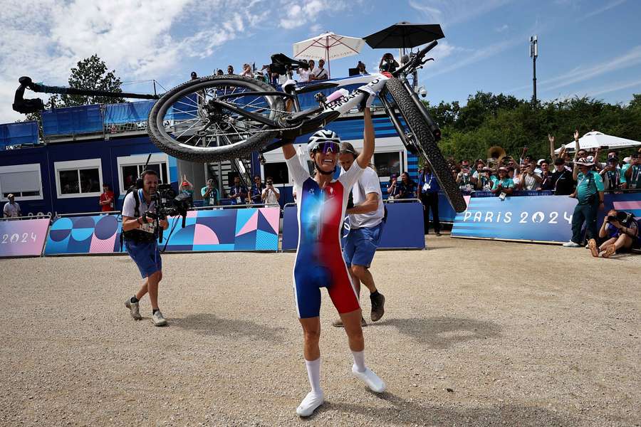 Pauline Ferrand Prevot lifts her bike after winning the race