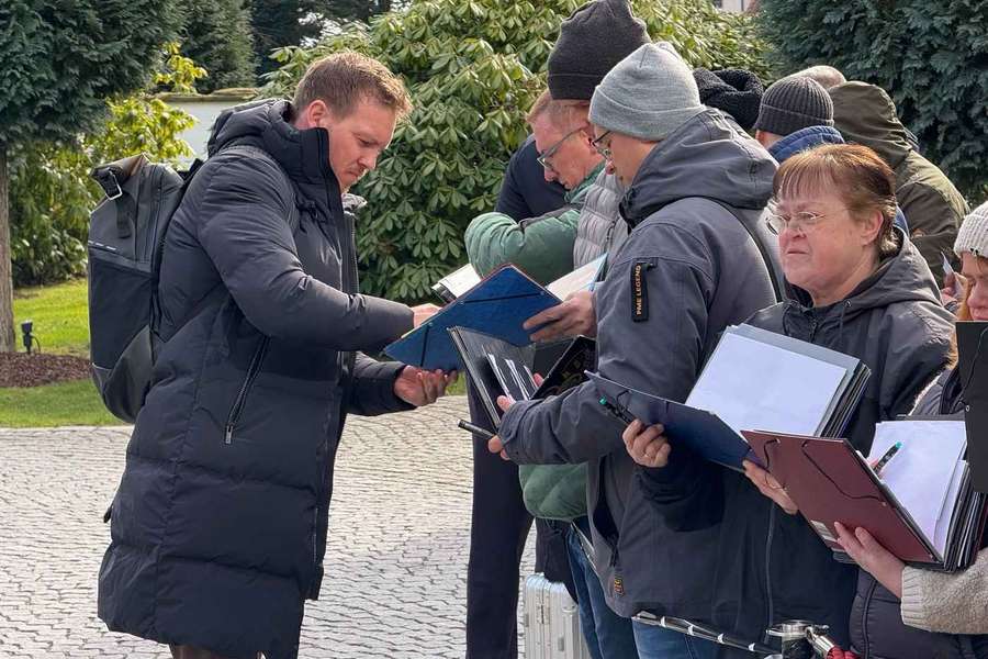 Bundestrainer Nagelsmann (l.) unterschreibt Autogramme beim Teamquartier in Dortmund