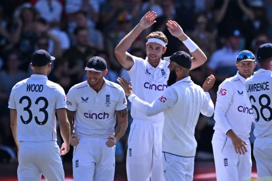 England's Stuart Broad (C) celebrates with teammates after taking the wicket of Australia's David Warner