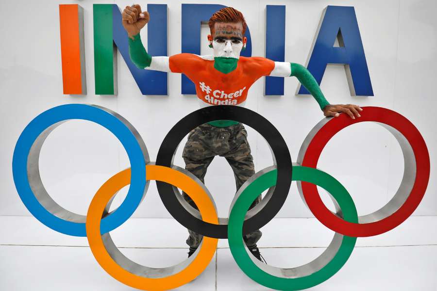 A fan poses with the Olympic rings as he cheers on India's team for the Tokyo 2020 Olympics