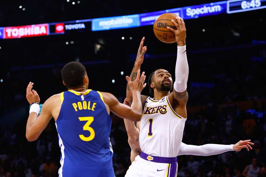 D'Angelo Russell of the Los Angeles Lakers scores in front of Jordan Poole and Stephen Curry of the Golden State Warriors