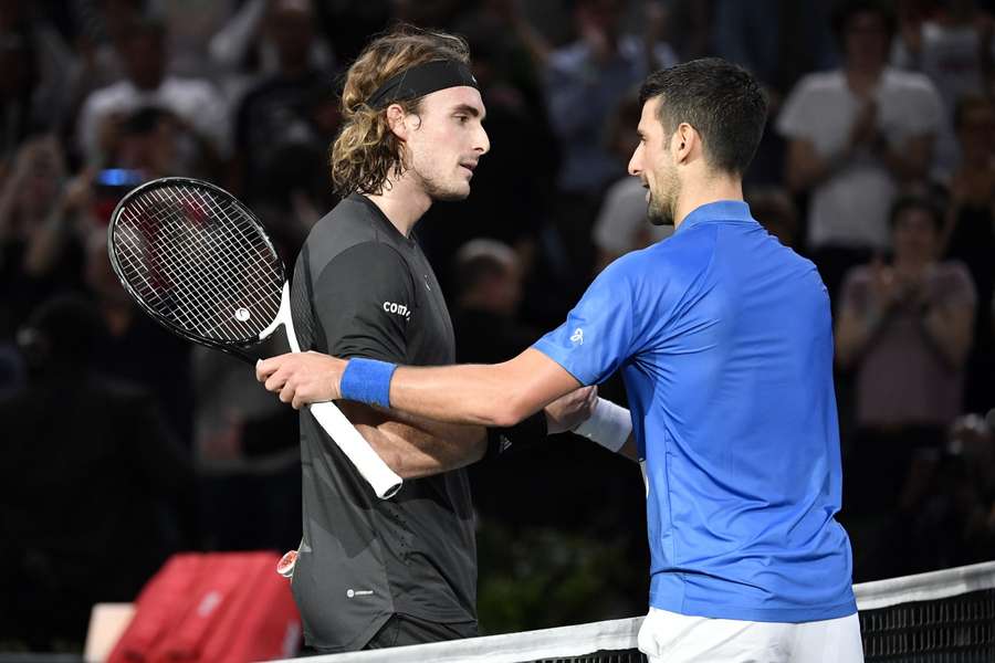 Stefanos Tsitsipas schudt de hand met Novak Djokovic