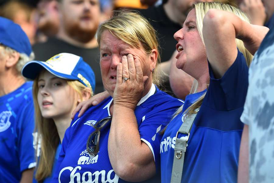 An Everton supporter wipes her tears before the English Premier League football match between Everton and Bournemouth