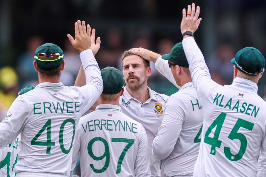 South Africa's Anrich Nortje (C) celebrates with teammates after dismissing Australia’s David Warner