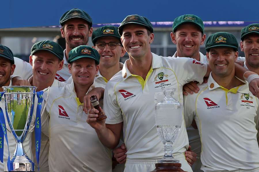 Australia's Pat Cummins (C) holds the urn trophy as Australia celebrate the drawn series and retaining The Ashes 
