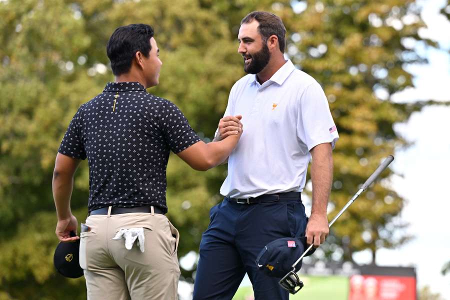 Scottie Scheffler of the US (right) shakes hands with Tom Kim of South Korea