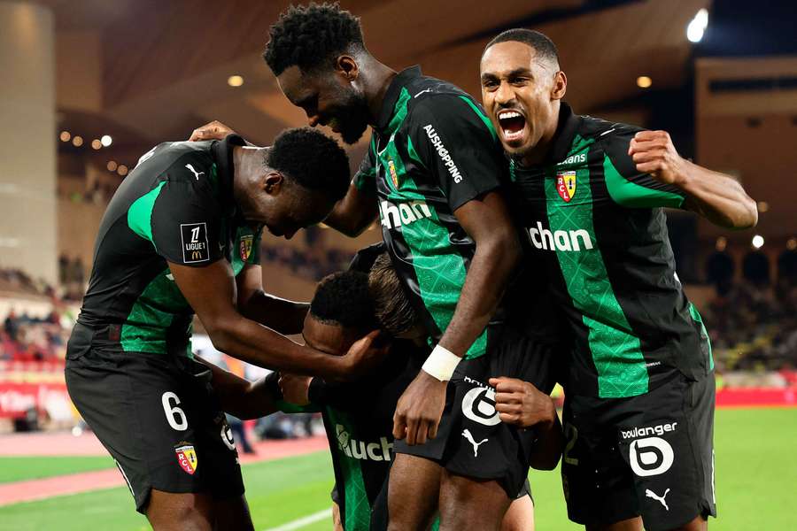Lens' players celebrate after scoring their third goal 