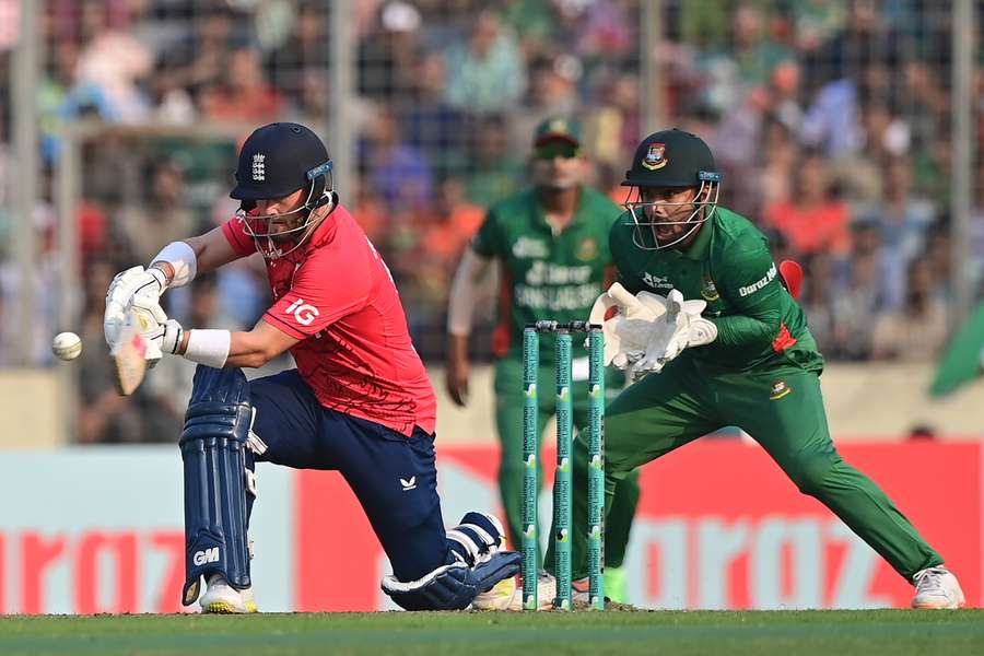 England's Ben Duckett (L) plays a shot