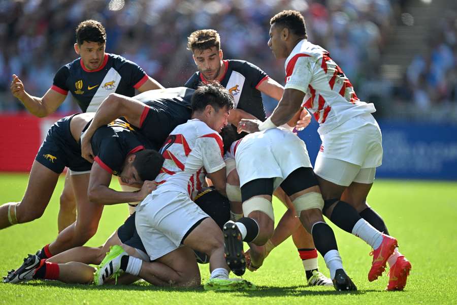 Japan's inside centre Ryoto Nakamura (centre L) fights for the ball