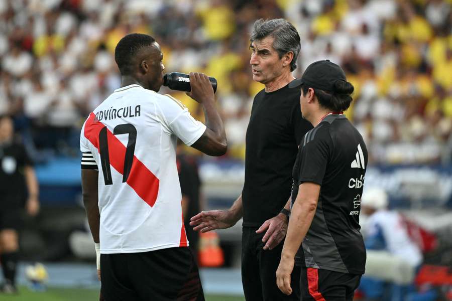 Óscar Ibáñez habla con Advíncula durante el último partido de Perú