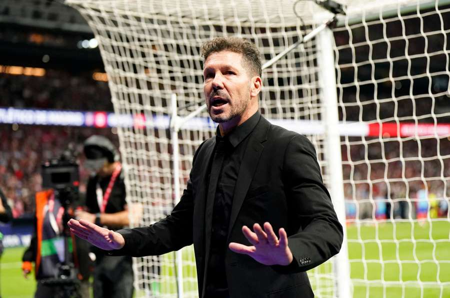 Diego Simeone talks to the Atletico Madrid fans as play is stopped due to crowd trouble