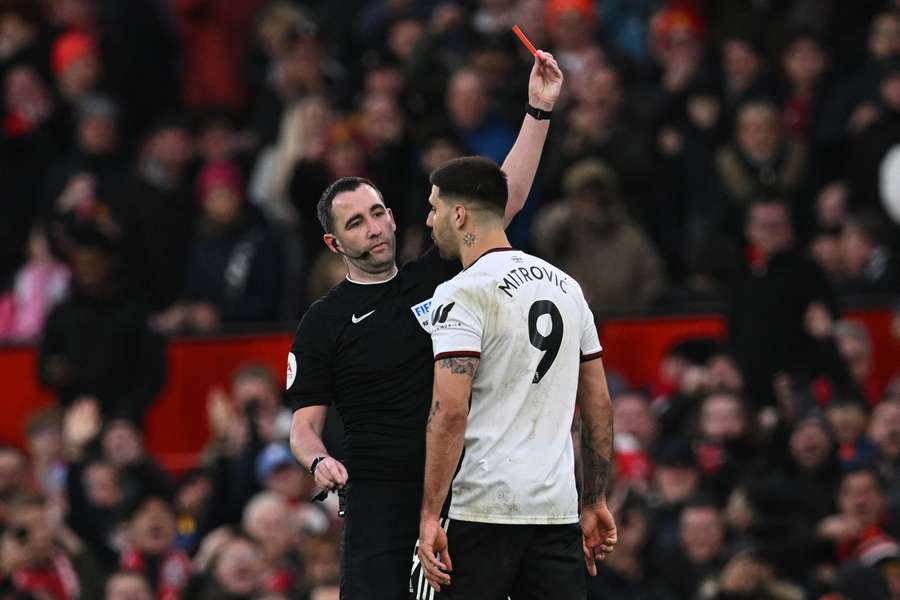 El árbitro inglés Chris Kavanagh (izda.) muestra la tarjeta roja a Aleksandar Mitrovic (dcha.) durante el partido de fútbol de cuartos de final de la FA Cup inglesa entre el Manchester United y el Fulham