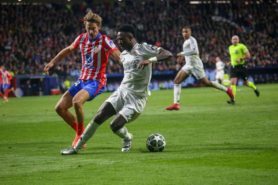 Atletico Madrid's Marcos Llorente and Real Madrid's Vini Jr. battle for the ball