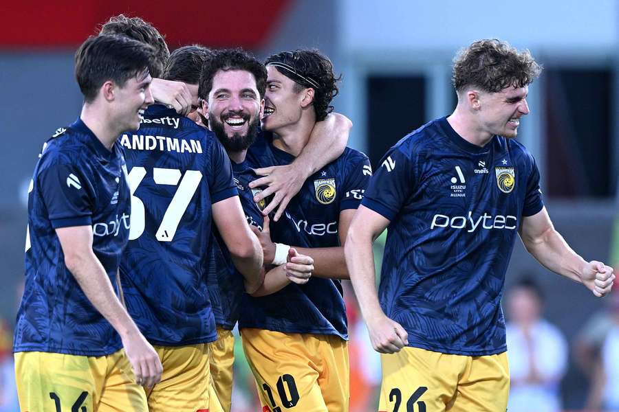 Central Coast Mariners players celebrate a goal during their win over Brisbane Roar in Redcliffe.