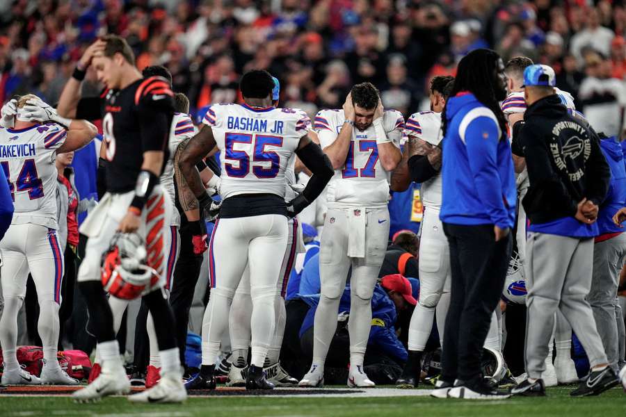 The Buffalo Bills gather as an ambulance parks on the field while CPR is administered to Buffalo Bills safety Damar Hamlin