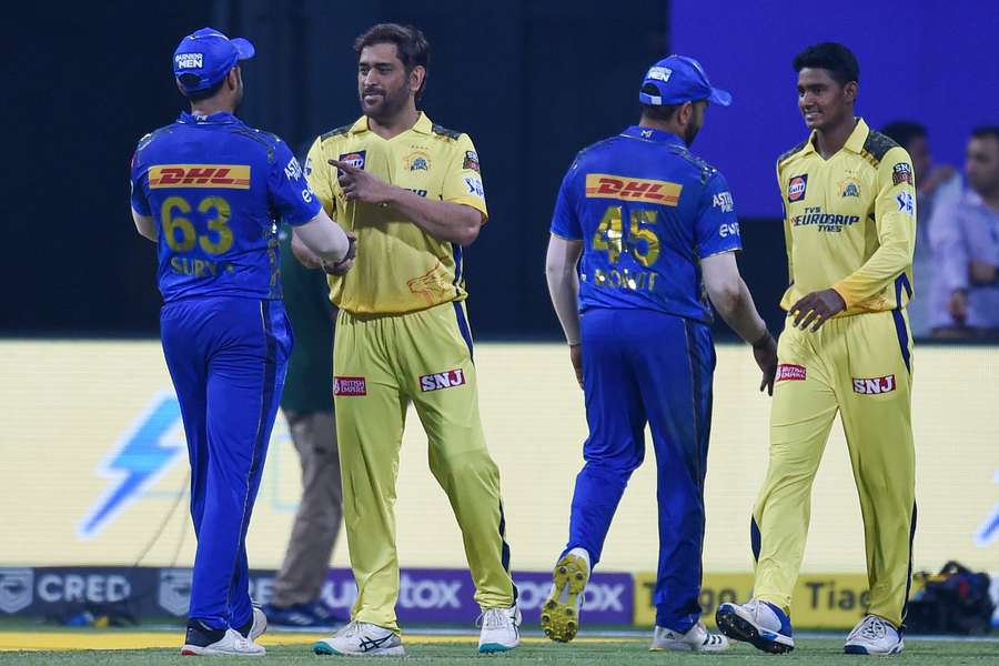 Chennai Super Kings' captain Mahendra Singh Dhoni (2L) greets Mumbai Indians' Suryakumar Yadav at the end of the IPL match