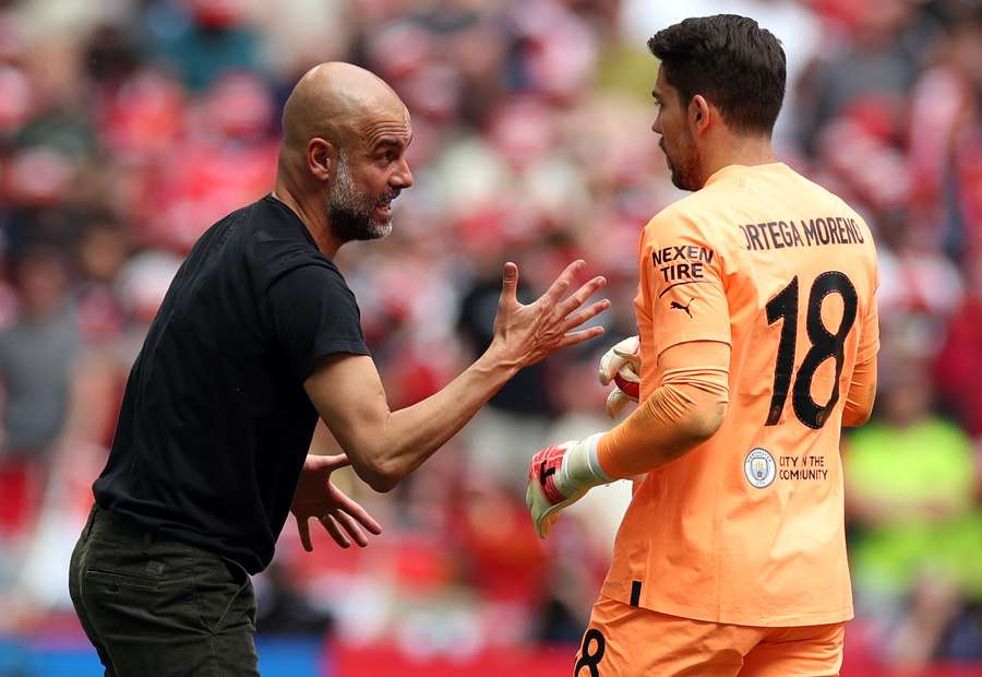 O treinador do City, Pep Guardiola, em diálogo com o seu guarda-redes Stefan Ortega.