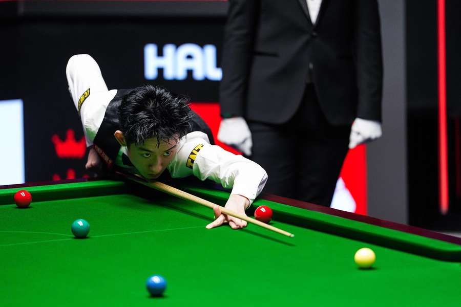 Wu Yize of China plays a shot against Mark Allen