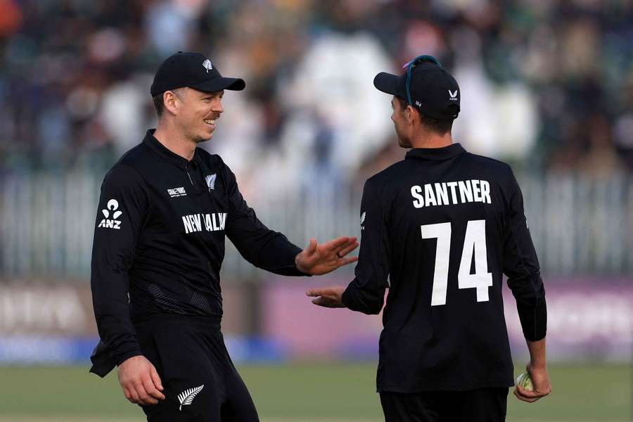 New Zealand's Mitchell Santner celebrates with Michael Bracewell after taking the catch to dismiss Bangladesh's Rishad Hossain