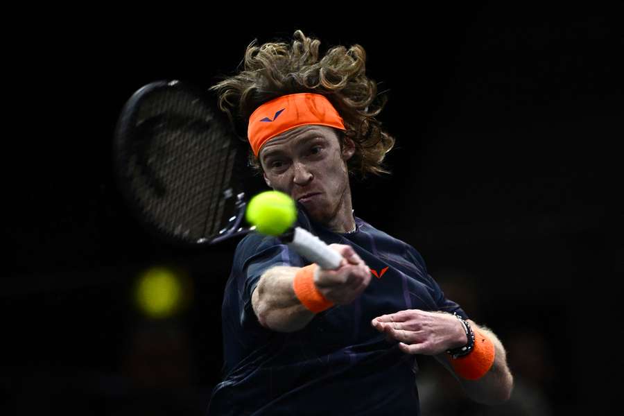 Andrey Rublev plays a forehand return to Novak Djokovic