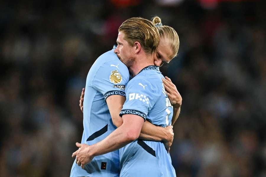 Kevin De Bruyne (vpravo) objímá Erlinga Haalanda při odchodu ze hřiště. 