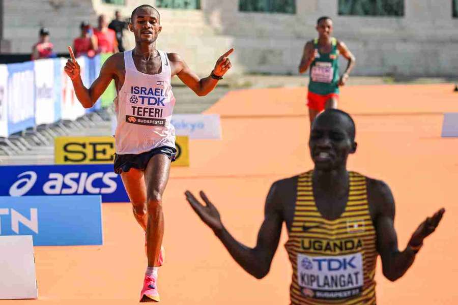 Victor Kiplangat celebrates after crossing the finish line as Maru Teferi and Leul Gebresilase approach