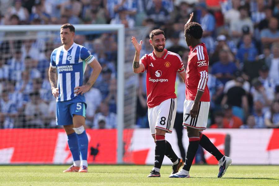 Manchester United's Bruno Fernandes celebrates breaking the Premier League record for assists in a season with Kobbie Mainoo