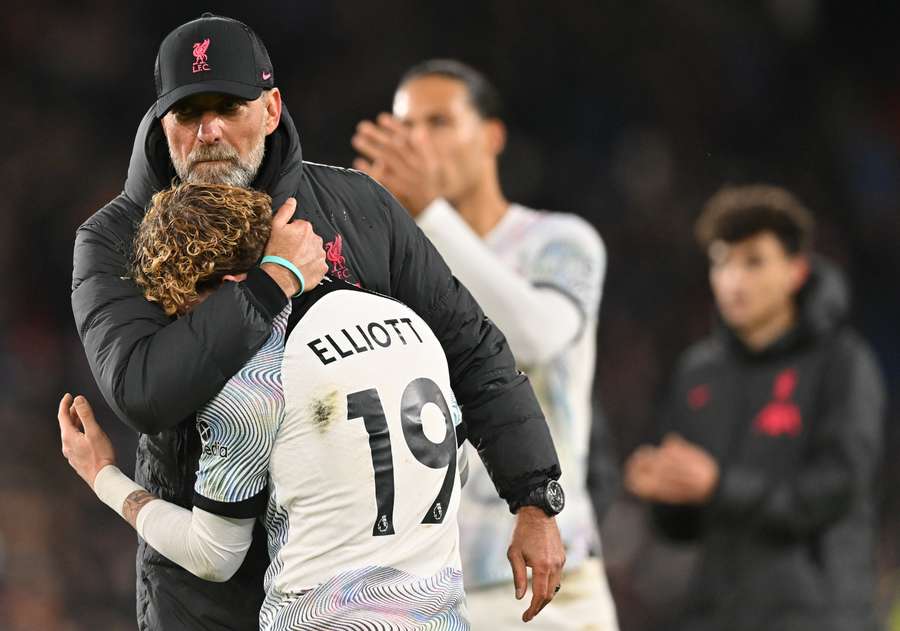 Liverpool's German manager Jurgen Klopp (L) embraces Liverpool's English midfielder Harvey Elliott