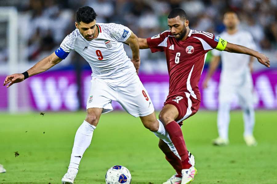 Qatar's Abdel Aziz Hatim and Iran's Mehdi Taremi battle for possession